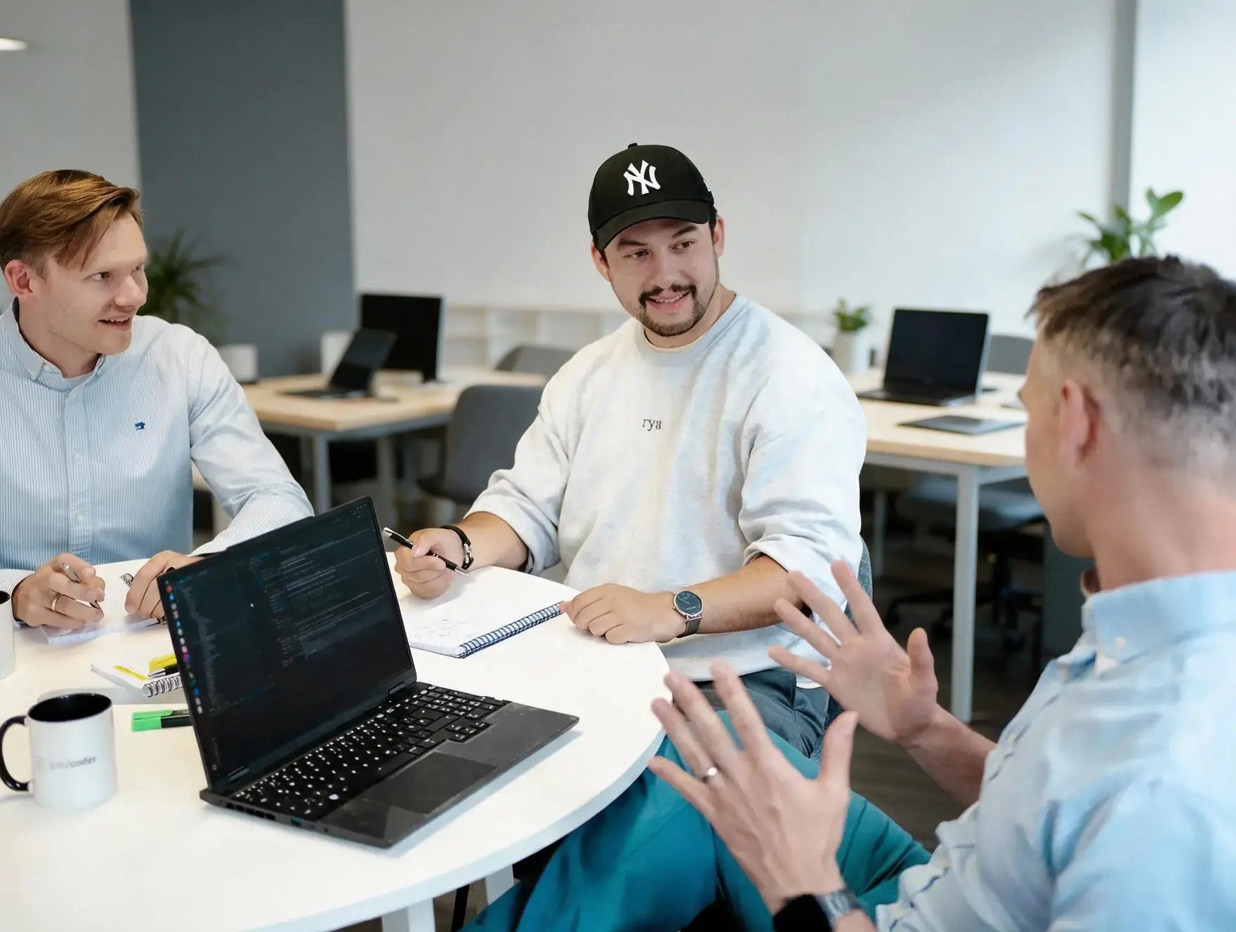 Entwickler arbeiten im Team am Laptop
